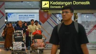 Penumpang tiba di terminal kedatangan Bandara Internasional Kualanamu, Deli Serdang, Sumatera Utara, Minggu (7/4/2024).