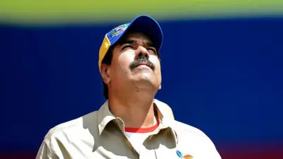 Николас Мадуро крупным планом в рубашке цвета хаки и желто-синей кепке смотрит вверх