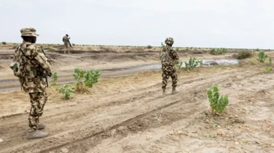 Awọn sọja meji to wọ aṣọ ologun gbe ibọn lọwọ