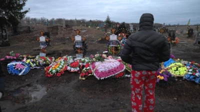 Dima looks at the graves of his mum, dad and grandparents