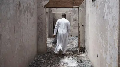 Aworan ọkunrin kan to wọ aṣọ adura, to n rin lọ ninu ile ijọsin ti wọn jo nina