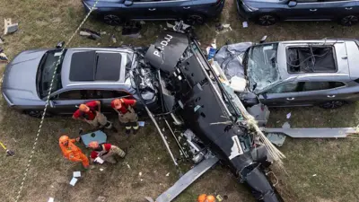 Una vista aérea muestra a bomberos trabajando en el lugar donde se estrelló un helicóptero en el barrio de Recreio dos Bandeirantes, en Río de Janeiro, el 14 de junio de 2026.