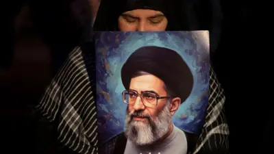 Mujer sostiene una imagen del fallecido ayatolá Jamenei en Teherán.