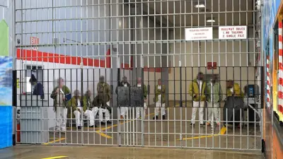 A number of male prisoners with faces blurred can be seen standing behind bars in Estelle Supermax Penitentiary in Huntsville, Texas