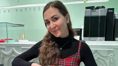 یوه نجلۍ موسک حالت کې چې ویښته یې پر یوه اوږه اړولي.