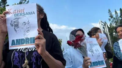 Empat orang perempuan dalam satu frame, mereka mengangkat poster bertuliskan karikatur wajah Andrie Yunus dengan tulisan kami bersama andrie.