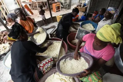 Des femmes préparent de la semoule de manioc pour la préparation de l'attieke à Abidjan, le 22 mai 2018.