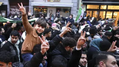 Expatriate Syrians gather with flags to celebrate the fall of the Assad regime in Syria on 8 December 2024 in Berlin, Germany