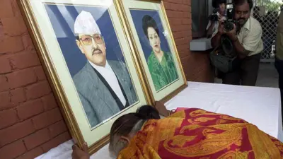 नारायणहिटी राजदरबारको मूलद्वारबाहिर राखिएको राजा वीरेन्द्र र रानी ऐश्वर्यको तस्बिरमा ढोग्दै एक महिला