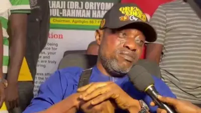 Surii Ilupeju wọ aṣọ olomi aro, gbohungbohun wa niwaju rẹ