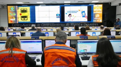 Centro faz envio de alertas por meio de smartphones para todo o país; imagem msotra equipe da Defesa Civil em escritório com computadores