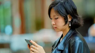 یک زن چینی در حال نگاه به موبایلش