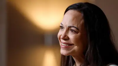 María Corina Machado previo a una conferencia de prensa el jueves, en Oslo, un día después de llegar a Noruega para recibir su premio nobel de la paz. Está maquillada, sonríe y tiene el cabello negro hasta los hombres. En la foto solo se ve su rostro. 