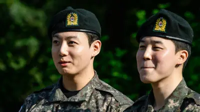 İki yeşil bereli Güney Koreli uzağa tebessüm ederek bakıyor.