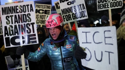 Una mujer grita en medio de una protesta con carteles contra ICE, la agencia federal de control migratorio, en Minesota. 