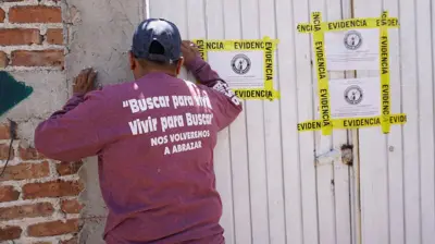 Un miembro del colectivo de búsqueda “Hasta Encontrarte” inspecciona los alrededores del predio donde se encontraron los cuerpos de 32 personas en una fosa clandestina en la comunidad de La Calera, en el municipio de Irapuato, estado de Guanajuato, México, el 4 de agosto de 2025.