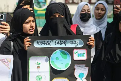 یو شمېر نجونې د ځمکې ورځې لوحه لېږدوي