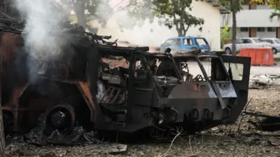 Ла Карлота ҳарбий ҳаво базасида йўқ қилинган зенит қўмондонлик қисми. Металл қорайиб, эгилиб қолган ва ундан тутун кўтарилмоқда.