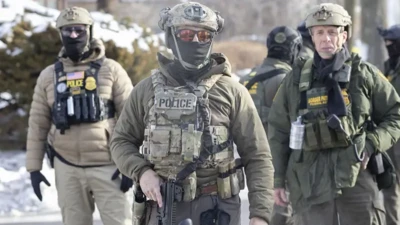 Yüzleri maskeli ve miğferli ICE polisleri, Minneapolis'te 37 yaşındaki Renee Nicole Good'un vurularak öldürüldüğü yerde ellerinde silahlarla görülüyor.