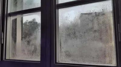 یک پنجره بخار گرفته با قطرات آب روی آن