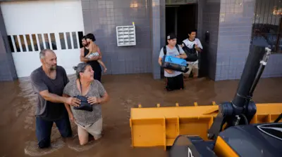 Moradores deixam prédio alagado em Eldorado do Sul (RS)