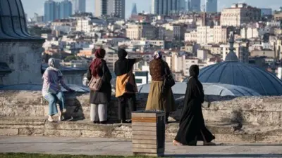 başörtülü 5 kadın istanbul silüetine bakıyor, arkaları dönük