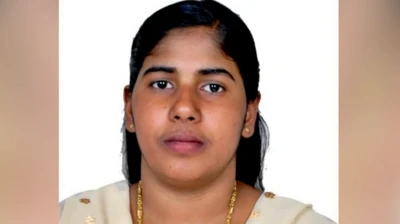 A picture of Nimisha Priya wearing gold jewellery, her hair tied back. She is wearing a beige-coloured Indian suit. 