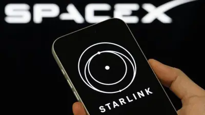 смартфон із заставкою Starlink на тлі лого SpaceX