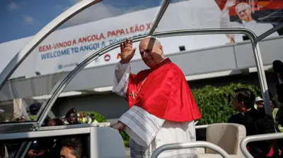 Popu Leo XIV na-efe aka site n'ụgbọala 'Popemobile' mgbe o rutere n'ọdọụgbọelu mba ụwa nke Luanda dị n'ụbọchị nke isii nke njem ndịozi ụbọchị iri na otu ya n'Afrịka,