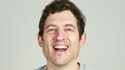 Elis James smiles at the camera