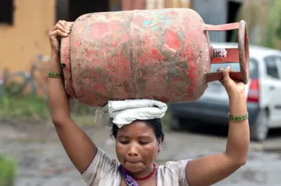 टाउकामा खाना पकाउने ग्यासको सिलिन्डर बोकेकी एक महिला