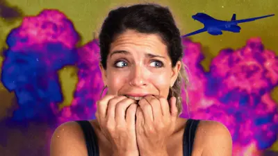 Дівчина в майці та з кільцем в носі гризе нігті, в голові - суміш страху та захвату, позаду полум'я синє та рожеве, а також літак - імітація вибухів та обстрілу