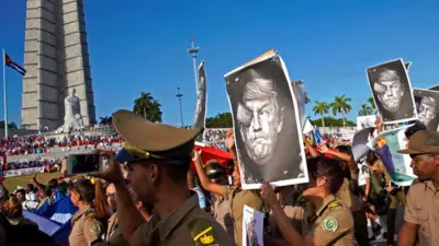 Кубинские военнослужащие несут карикатуры на президента США Дональда Трампа, проходя мимо памятника Хосе Марти во время первомайского парада на площади Революции в Гаване