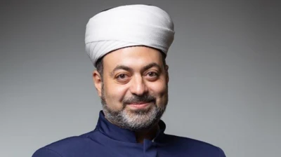 چهره یک روحانی که به دوربین نگاه میکند و لبخند میزند