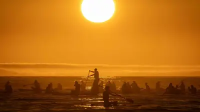 People paddle in the sea at Copacabana Beach