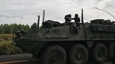 Seorang tentara naik kendaraan berat.