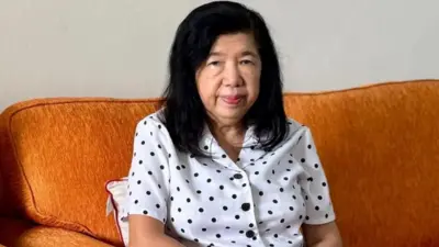 سوزانا لیو روی مبل زرد رنگی نشسته به دوربین نگاه می‌کند