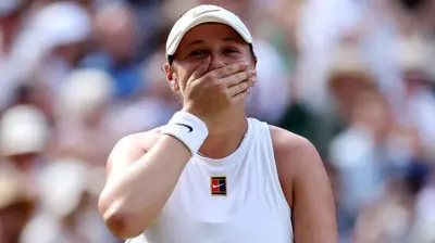 Amanda Anisimova covers her mouth with her hand
