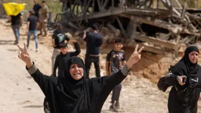 Pessoas deslocadas atravessam uma ponte que liga o sul do Líbano ao resto do país. A ponte em Qasmiyeh foi gravemente danificada por um ataque aéreo israelense. Foto de 17 de abril de 2026