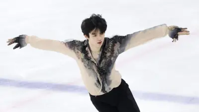 밝은 살구색의 상의와 검정 하의 피겨스케이팅 복장을 한 차준환 선수가 얼음 위에서 팔을 펼치고 연기를 선보이고 있다