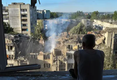 Чоловік оглядає місце російського ракетного удару по житловому будинку у Львові, 30 липня 2026 року.