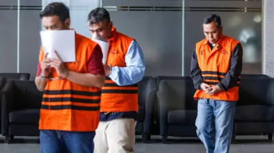 Kepala KPP Madya Jakarta Utara Dwi Budi (tengah) bersama Tim Penilai di KPP Madya Jakarta Utara Askob Bahtiar (kiri), dan Kepala Seksi Pengawas dan Konsultasi KPP Madya Jakarta Utara Agus Syaifudin (kanan) menggunakan rompi tahanan usai menjalani pemeriksaan di Gedung Merah Putih KPK, Jakarta, Minggu (11/1/2026).