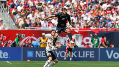 Christian Pulisic (#10) dari Amerika Serikat menyundul bola melewati Joshua Kimmich (#6) dari Jerman dalam pertandingan persahabatan internasional antara Amerika Serikat dan Jerman di Soldier Field pada 6 Juni 2026 di Chicago, Illinois.