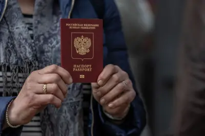 Женщина показывает российский паспорт, видны два кольца у нее на пальцах и платок на шее