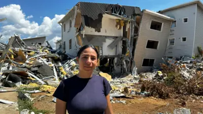 Karolyn Sánchez frente a los escombros de lo que era su edificio.