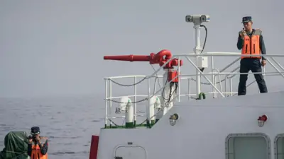 Chinese coast guard officers filming aboard their ship