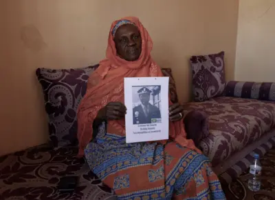Maïmouna Alpha Sy, membre du collective des veuves de Mauritanie tenant un portrait de son époux, Baïdy Alassane Ba, tué en novembre 1990. 