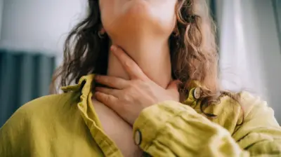 boğazını tutan bir kadın