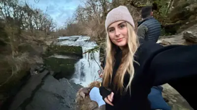 Chelsea can be seen out walking in front of a stream.