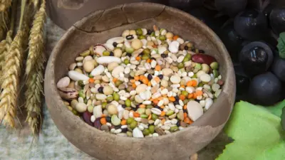 Bir yuvarlak ahşap kasenin içinde renkli tohumlar var